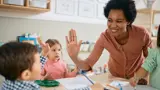 Teacher high fiving a toddler