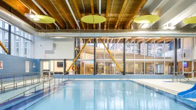 An indoor pool with an accessible ramp and small slide.