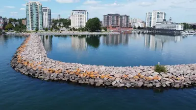 Confederation Basin Promenade. Close-up of rocks with buildings in the background