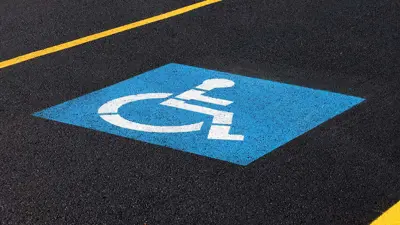 Accessible symbol painted into the asphalt in a parking spot