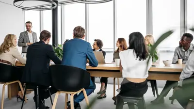 Many people in an office sitting around a table