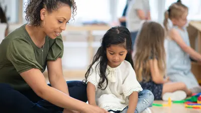 Teacher assisting child in class