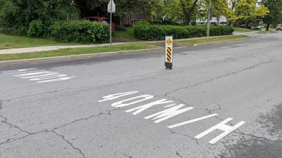 Kingston street with 40 KM/H in stencil on the road with a slow bollard in the middle of the road