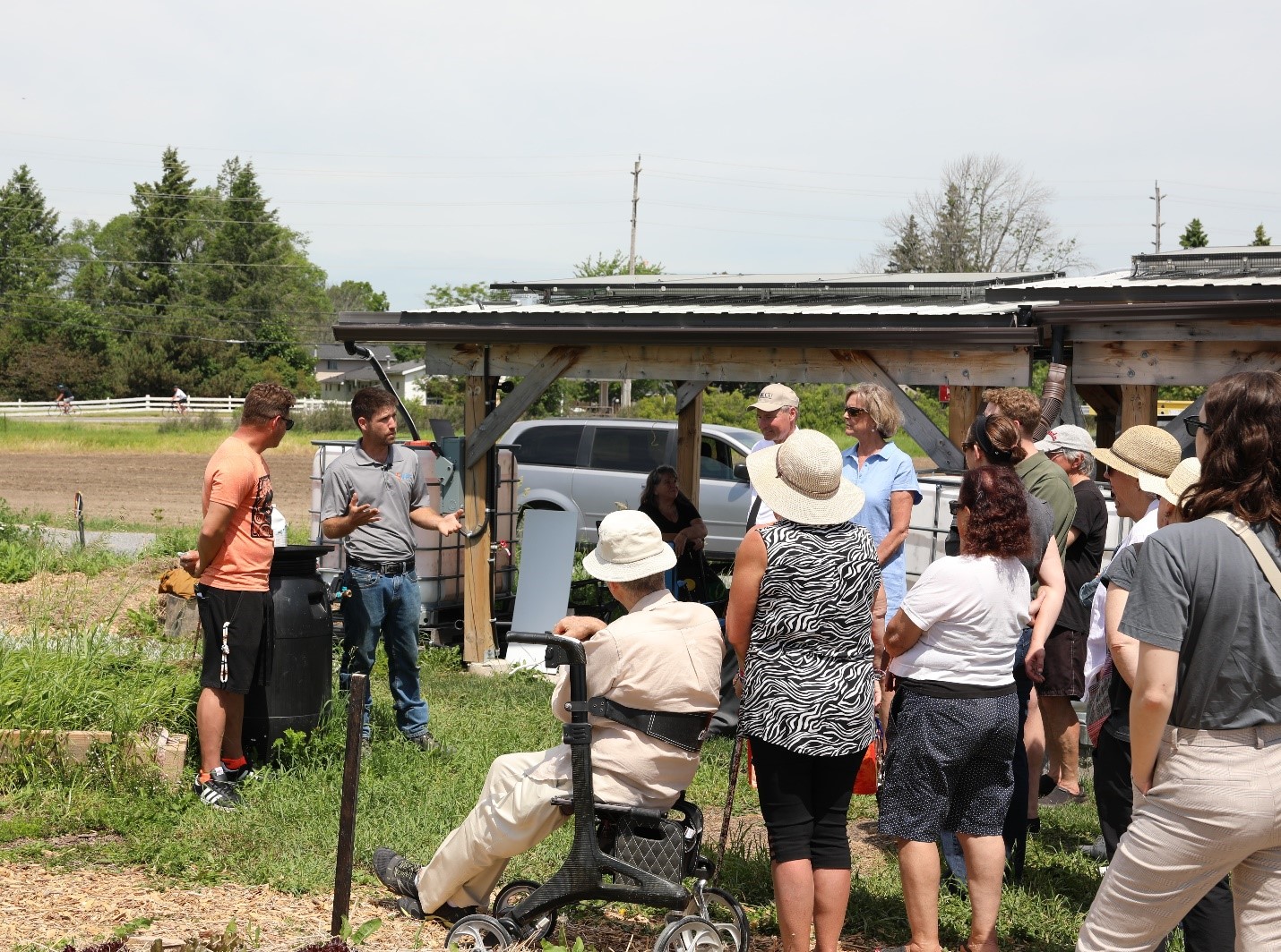 Shawn Melnyk (All Our Relations Land Trust) and Eric Collins (CDK Energy Solutions) speak to attendees about how the solar-powered irrigation system works.