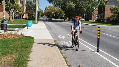 A man riding down a cycle path on a main road in Kingston