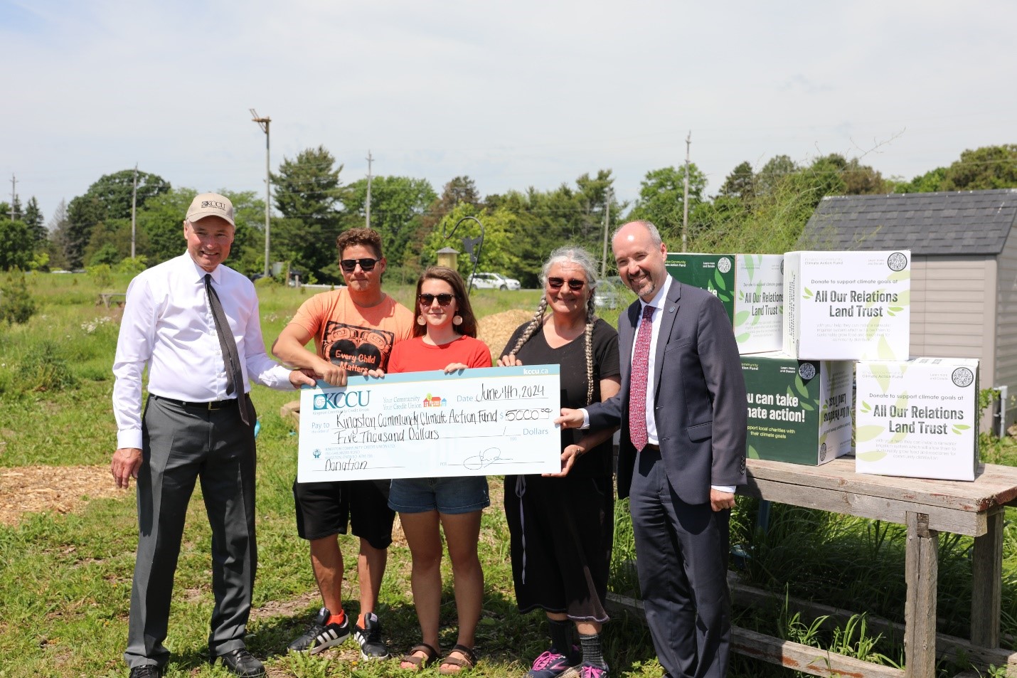Jon Dessau, CEO of the Kingston Community Credit Union, is joined by Mayor Bryan Paterson to present a cheque to Shawn Melnyk, Kaitlyn Patterson and Maureen Buchanan of All Our Relations Land Trust.