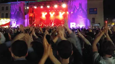 Crowd of people enjoying concert at night in Springer Market Square