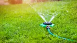 A water sprinkler in use on a lawn