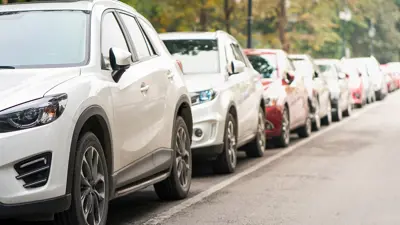 A row of cars parked on the side of a street